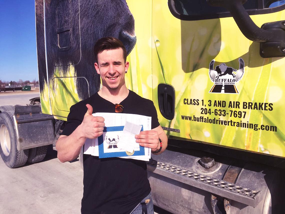 A smiling Buffalo student beside a branded truck